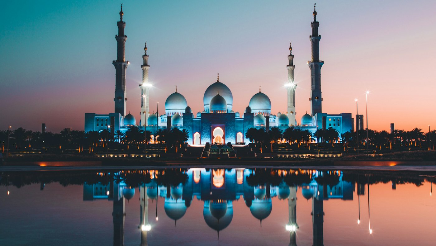 Sheikh Zayed Grand Mosque in Abu Dhabi reflected in water at dusk