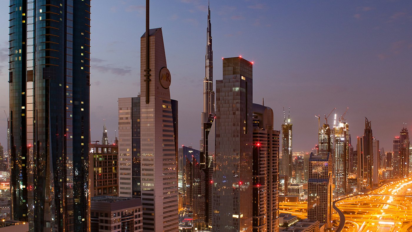 Dubai skyscrapers and highways lit up at night