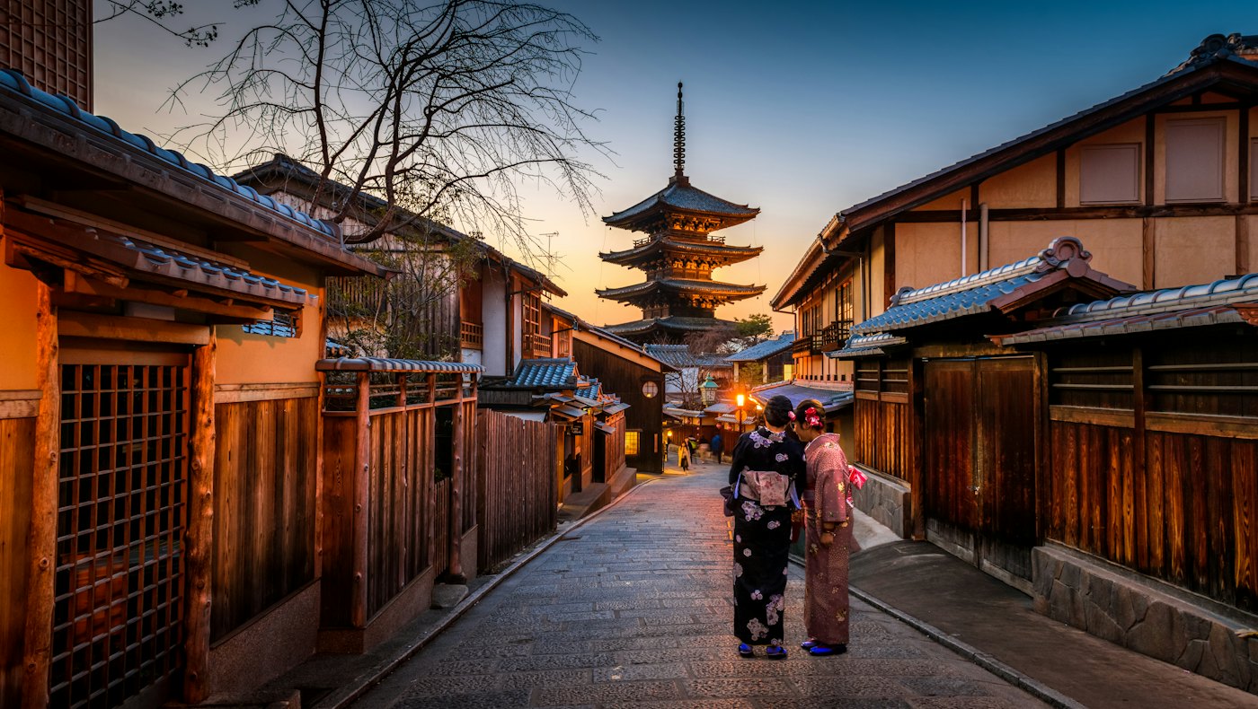 Traditional street in Kyoto at dusk with a pagoda in the distance