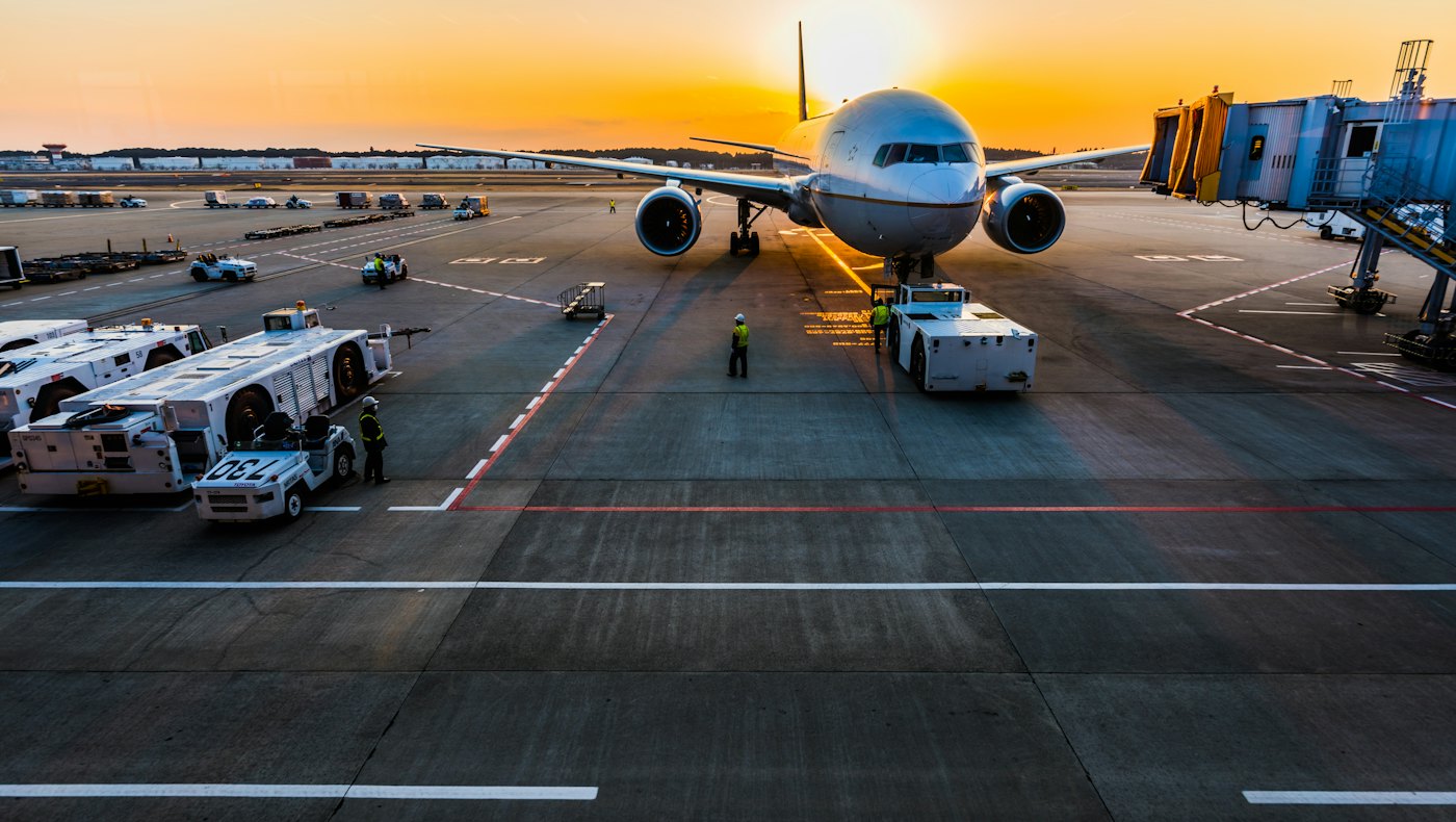 Aircraft parked at an airport gate at sunset