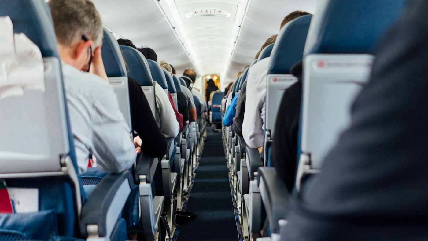 Passengers seated in an aircraft economy cabin