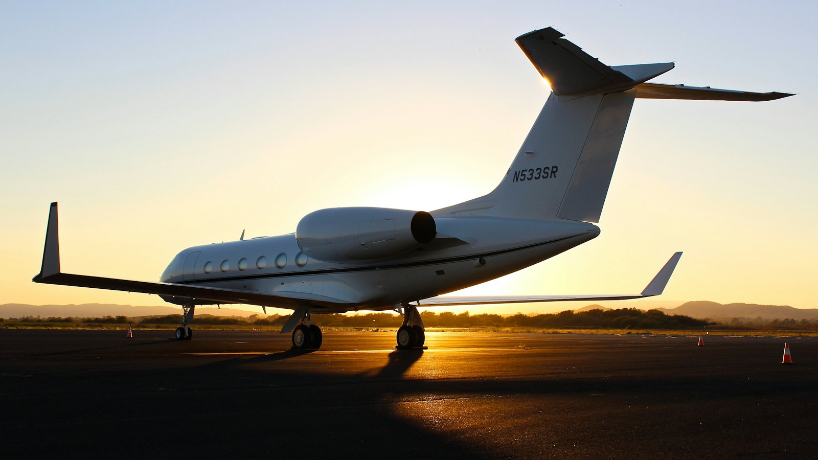 Private jet on the runway at sunset
