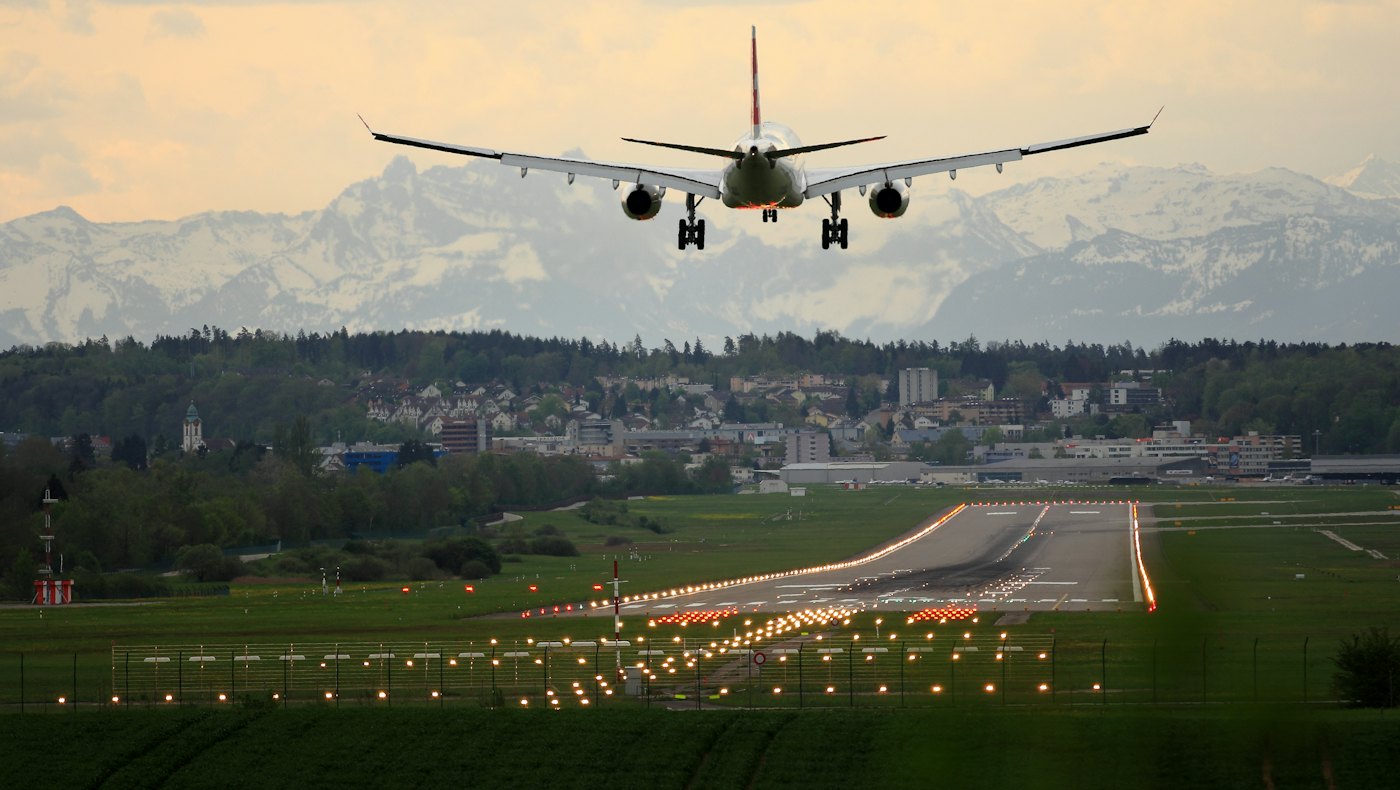 Passenger jet coming in to land over a lit runway